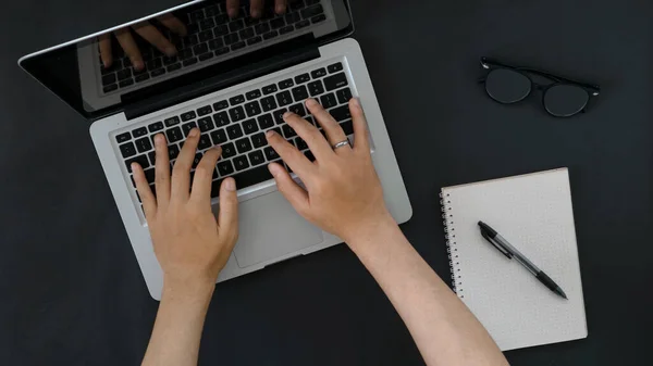 hand with laptop notebook on black background 