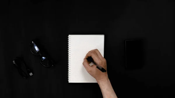 Top View hand with notebook on black background 