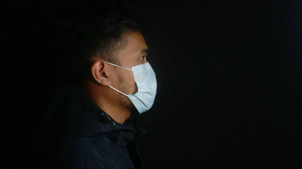 Asian man wearing protective mask isolated over background