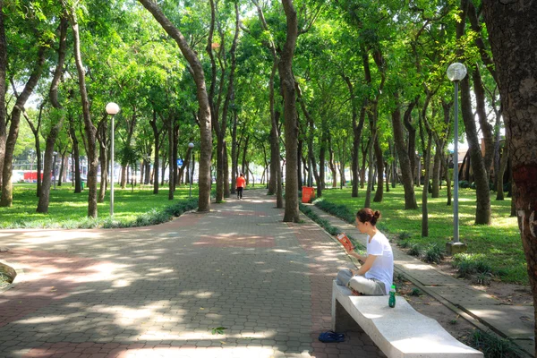 Ho Chi Minh city, Viet nam - July 5, 2015: Unknown, a woman is reading book relaxing on a bench in a park in Ho Chi Minh City — 图库照片