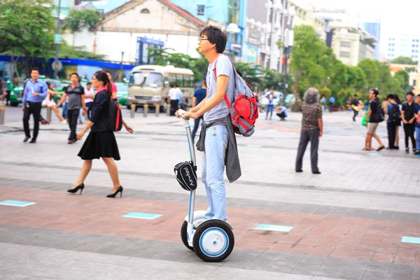 Hochiminh City, Vietnam - July 8, 2015: Man riding a Segway electric vehicle two wheels on a young tour sightseeing gyropode on Walking Street Nguyen Hue Street, HoChiMinh city center — Stock Photo, Image