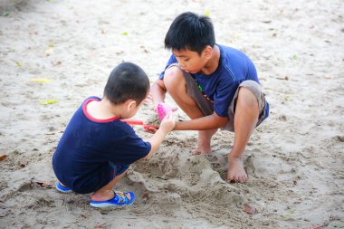 Hochiminh City, Vietnam - June 21, 2015: Unknown, two cute little boys playing in the sand at the city park HoChiMinh, Vietnam