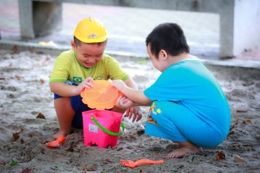 Hochiminh City, Vietnam - June 21, 2015: Unknown, two cute little boys playing in the sand at the city park HoChiMinh, Vietnam