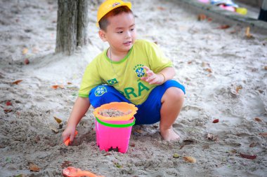 Hochiminh City, Vietnam - June 21, 2015: unidentified, cute boy playing alone in a park sand in Ho Chi Minh City, Vietnam