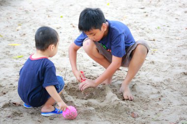 Hochiminh City, Vietnam - June 21, 2015: Unknown, two cute little boys playing in the sand at the city park HoChiMinh, Vietnam
