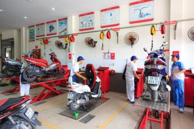 Hochiminh City, Vietnam - June 23, 2015: professional motorcycle repairman at a service center of Honda motorcycles in Ho Chi Minh City, Vietnam clipart