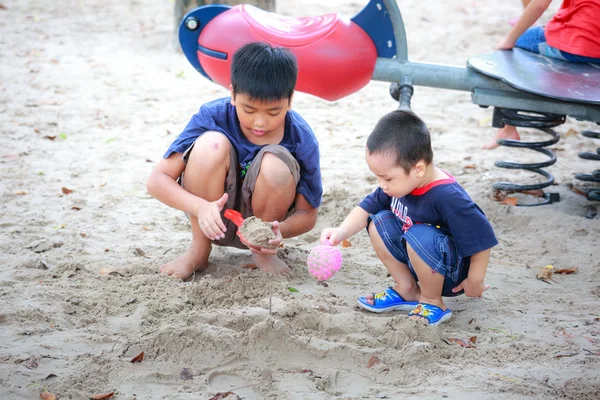 Hochiminh City, Vietnam - June 21, 2015: Unknown, two cute little boys playing in the sand at the city park HoChiMinh, Vietnam
