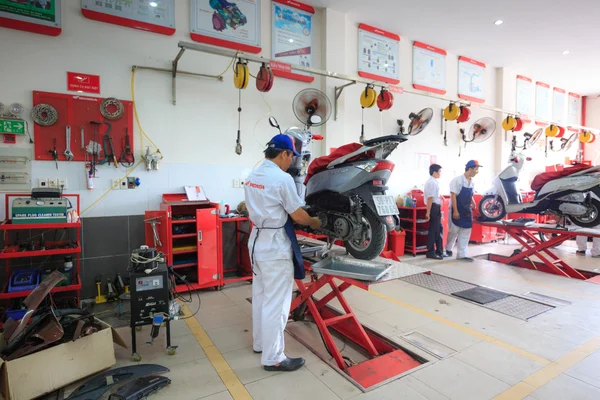 Hochiminh City, Vietnam - 23 de junio de 2015: reparador profesional de motocicletas en un centro de servicio de motocicletas Honda en Ho Chi Minh City, Vietnam — Foto de Stock