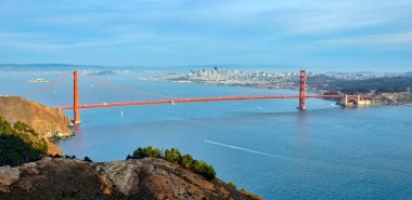 Golden Gate Köprüsü, arka planda San Francisco siluetinin panoramik görüntüsüyle Hawk Hill 'in tepesinden görüldüğü gibi..