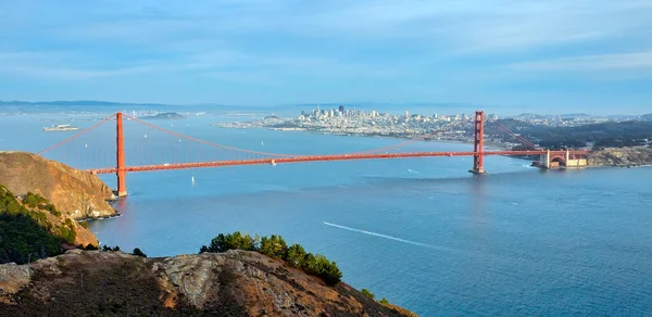 Golden Gate Köprüsü, arka planda San Francisco siluetinin panoramik görüntüsüyle Hawk Hill 'in tepesinden görüldüğü gibi..