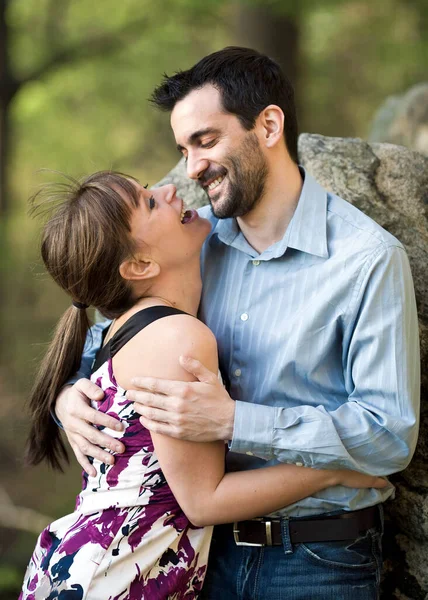 公園で笑って抱き合っている若いカップル ストック写真