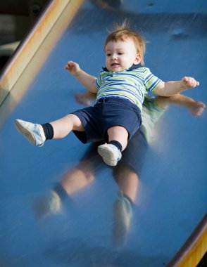 1 yaşındaki bir çocuk oyun parkından kayıyor..