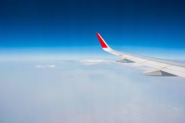 Bulutların üzerinde uçan bir uçağın kanadı