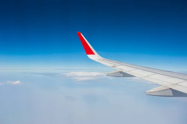在云层之上飞行的飞机的翼 — 图库照片
