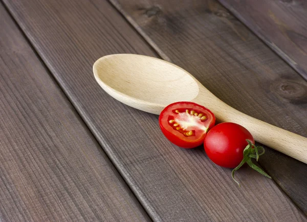 Tomates frescos y cuchara en la mesa de madera oscura — Foto de Stock