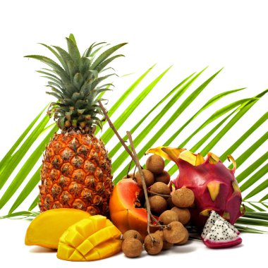 Bright still life of different tropical fruits on a green palm l clipart