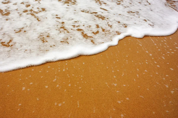 Ola de mar con espuma sobre arena — Foto de Stock