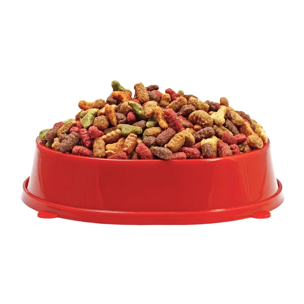 Comida para gatos o perros seca multicolor en tazón rojo aislado en blanco Imagen de archivo