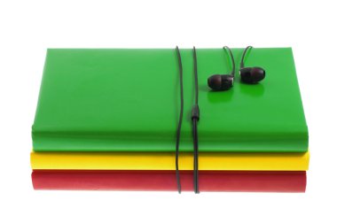 Kulaklık ve beyaz bir arka plan üzerinde renkli kitap yığını