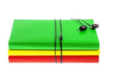 Kulaklık ve beyaz bir arka plan üzerinde renkli kitap yığını