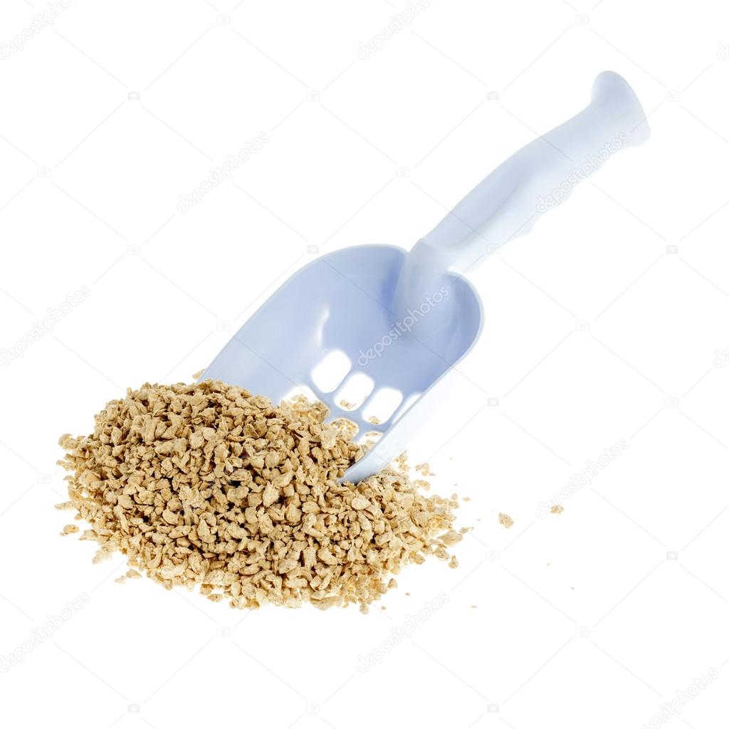 Plastic scoop for cleaning cat litter and a pile of filler on a white background