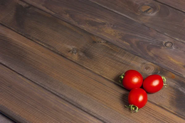 Verse tomaten op de donkere houten tafel — Stockfoto