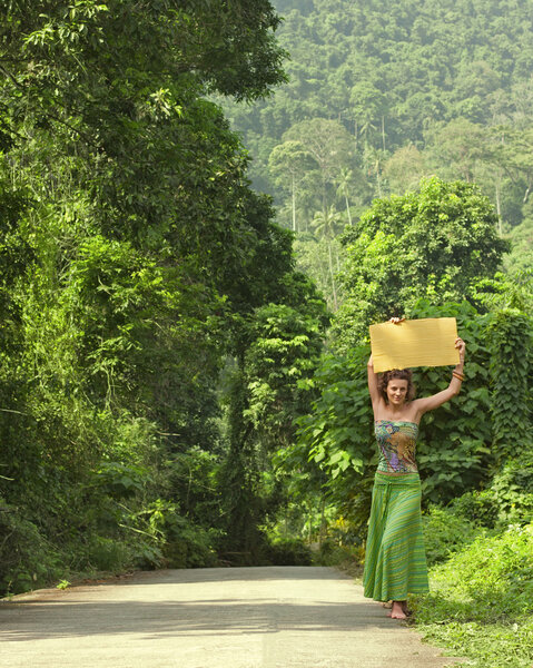 Beautiful young woman hitch-hiking travels through Asia. It stan