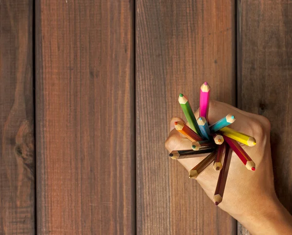 Conjunto de lápis coloridos em mãos femininas em um fundo de w escuro — Fotografia de Stock