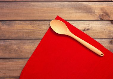 Yuvarlak ip peçete veya stand, kırmızı yer minderi ve bir tahta kaşık