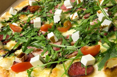 İştah açıcı pizza jambon, salam, roka, domates, fetaksa, balsamik closeup ile