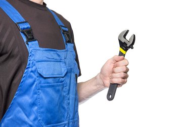 İş giyisi adam mekanik bir İngiliz anahtarı beyaz arka plan üzerinde izole elinde tutan