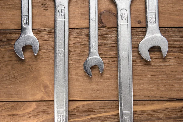 Set of wrenches. Wrenches in several different sizes on natural wooden background.