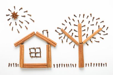 Kavram yemek. Baharatlar yapılan bir rakam fikri. House, güneş, ağaç ve tarçın, karanfil ve beyaz arka plan üzerinde izole anasonu yapılmış çim