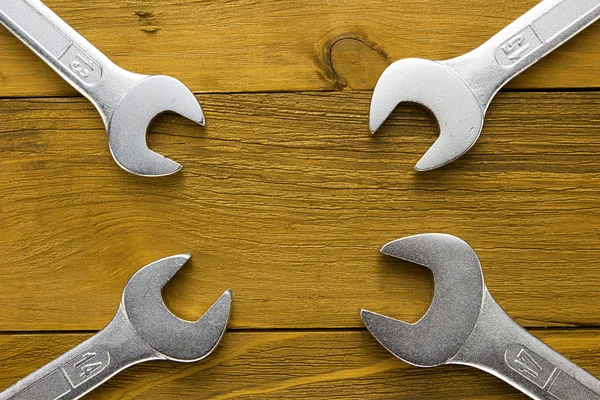 Set of wrenches. Wrenches in several different sizes on natural wooden background. — Stock Photo, Image