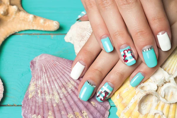 Francuski manicure - piękne kobiety wypielęgnowane ręce z morskich manicure z kryształkami na tle muszle i rozgwiazdy — Zdjęcie stockowe