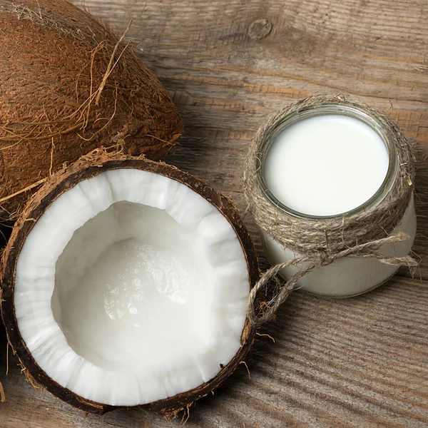 Cocos exóticos, mantequilla de coco y leche sobre fondo de madera. Concepto de alimentos orgánicos saludables. Concepto de belleza y SPA . —  Fotos de Stock