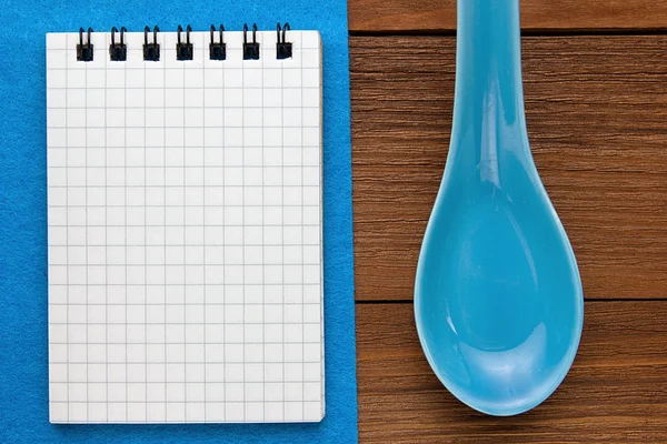 Menu background. Cook book. Recipe note book on a blue background and a wooden texture. Clay spoons and a Notepad. — Stock Photo, Image