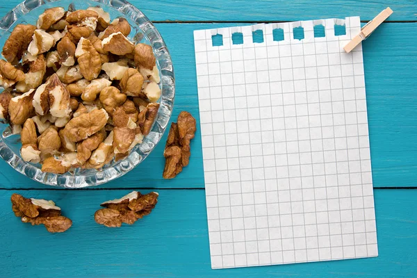 Menu background. Cook book. Recipe notebook with walnuts on turquoise wooden texture