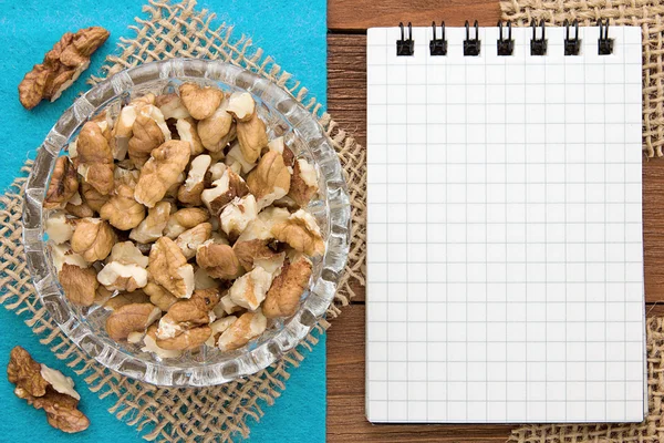 Fondo del menú. Libro de cocina. Cuaderno de recetas con nueces sobre fondo azul y tabla de madera . —  Fotos de Stock