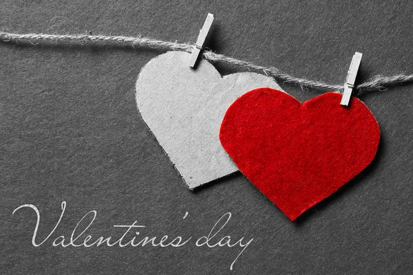 Black white red. Valentine's day. Two hearts from felt and cardboard on rope with clothespin on black and white background — Stock Photo, Image