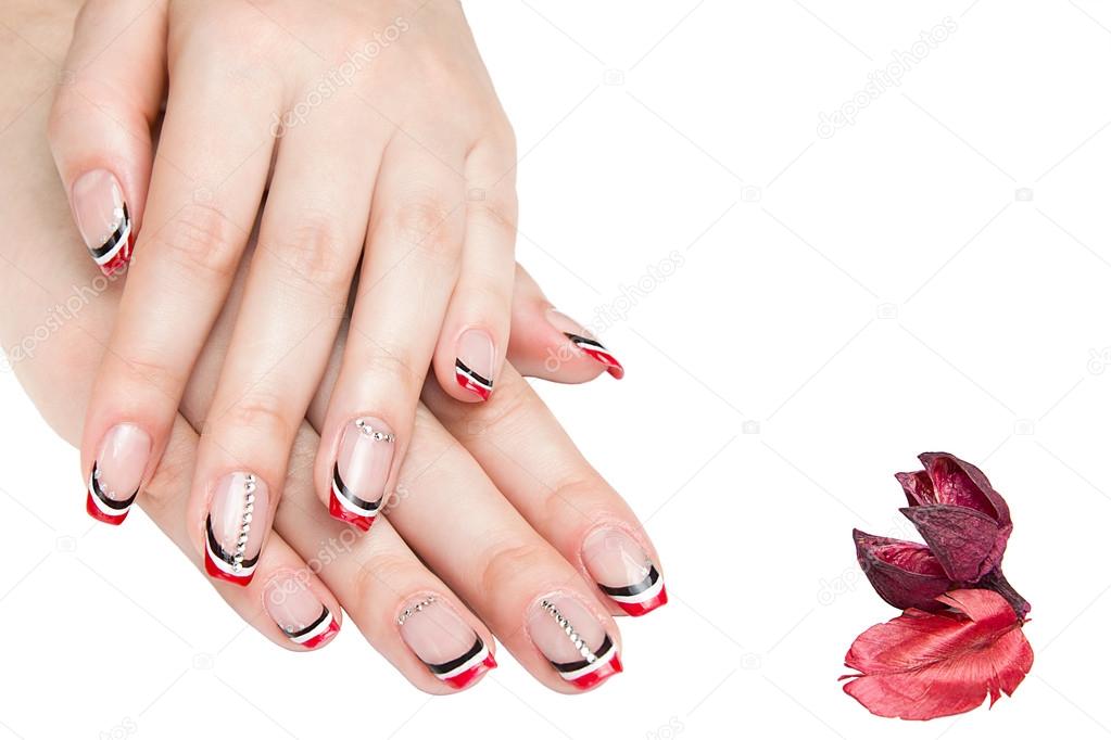 French manicure - beautiful manicured female hands with red black and white manicure with rhinestones isolated on white background