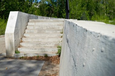 Sabah güneşiyle aydınlatılan taş merdiven. Taş kahverengidir ve çimento harcı ile birleştirilmiştir. Merdivenler kayalık bahçede ya da parkta.