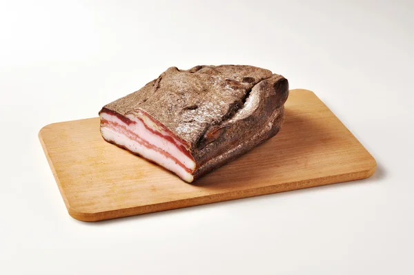 Speck mit Pfeffer auf Schneidebrett — Stockfoto