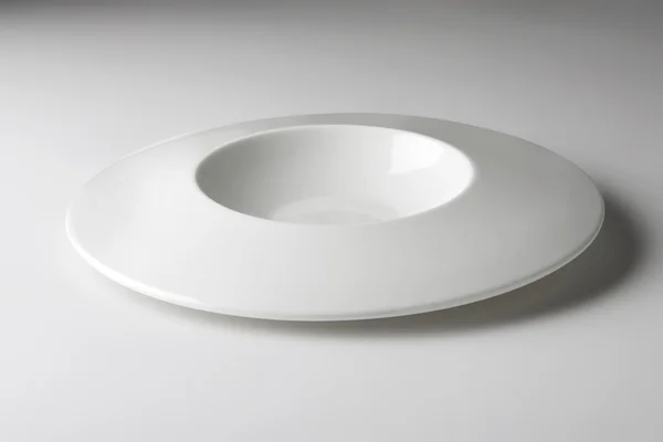 Plaque ronde blanche avec un design spécial sur une table blanche — Photo