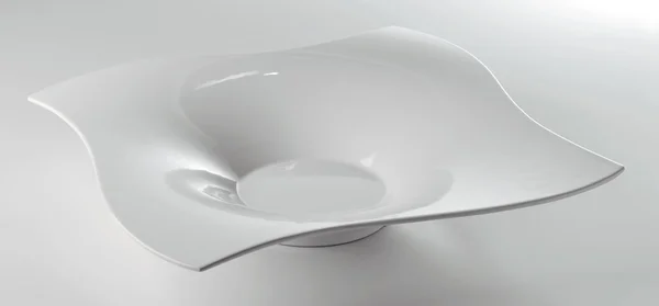 Белая квадратная тарелка со специальным дизайном на белом столе — стоковое фото
