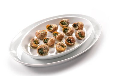 Salyangozlar beyaz oval bir tabakta Bourguignonne pişirdi.