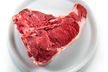 Beyaz arkaplanda çiğ biftek izole edilmiş.