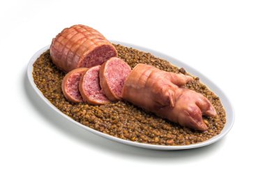 Stuffed pork foot sliced on lentils in oval plate clipart