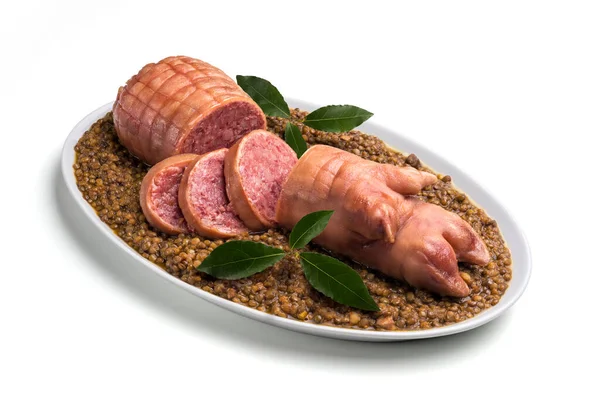 Stuffed pig foot on lentils with bay leaf in oval plate