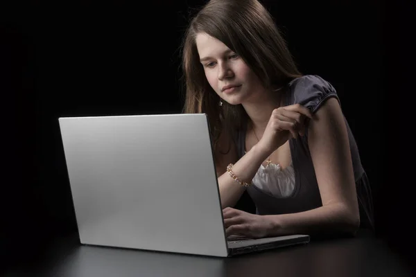 Młoda Dziewczyna Długimi Brązowymi Włosami Laptopa Czarnym Tle — Zdjęcie stockowe